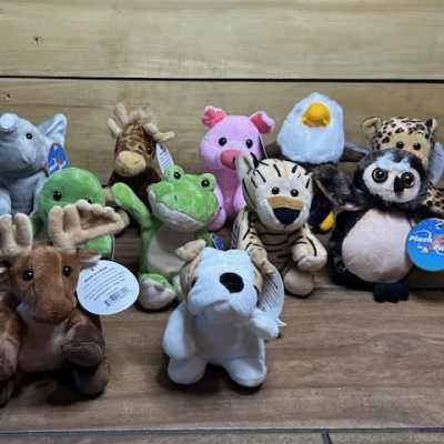 Assorted plush animal toys arranged on a wooden surface