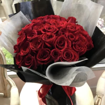 Bouquet of red roses wrapped in black and silver paper