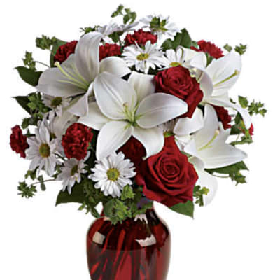 Red roses and white lilies in a red glass vase