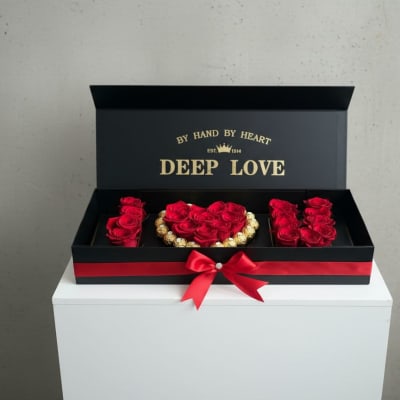 Black gift box with red roses and a red ribbon bow