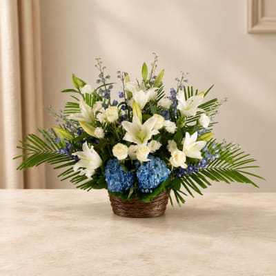 White lilies and blue hydrangeas in a wicker basket
