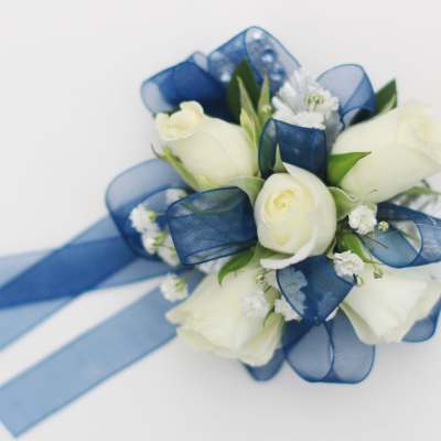 White rose corsage with blue ribbon accents