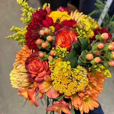 Handheld bouquet of orange, red, and yellow flowers