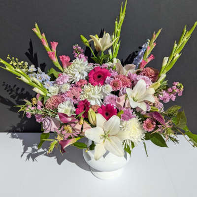 Mixed pink and white floral arrangement in a white vase