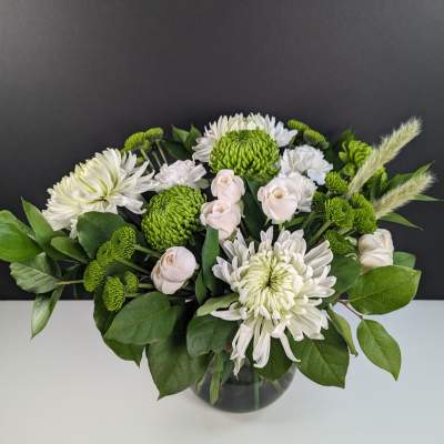White and green floral arrangement in a glass vase