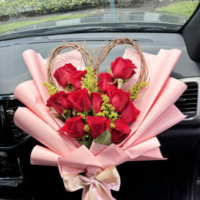 Bouquet of red roses wrapped in pink paper with a ribbon