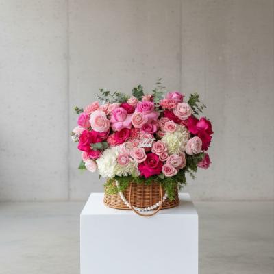 Pink and white rose bouquet in a wicker basket