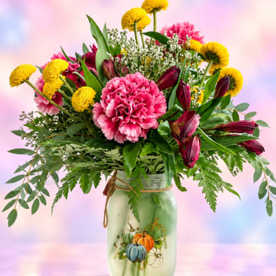 Pink and yellow mixed bouquet in a painted mason jar vase