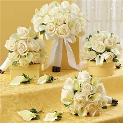 White rose and calla lily bouquets with ribbon on a yellow table