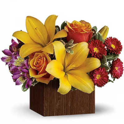 Yellow lilies and orange roses in a wooden cube vase