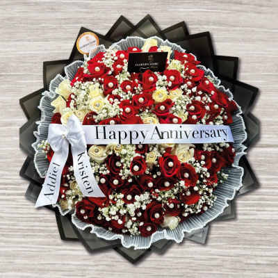 Round bouquet of red and cream roses with a Happy Anniversary ribbon