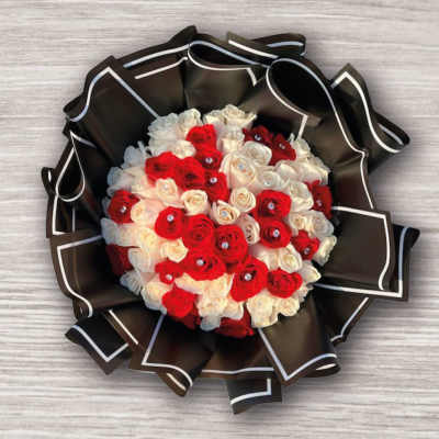 Bouquet of red and white roses wrapped in black paper