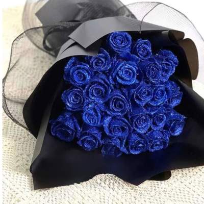 Bouquet of glittery blue roses wrapped in black paper and mesh