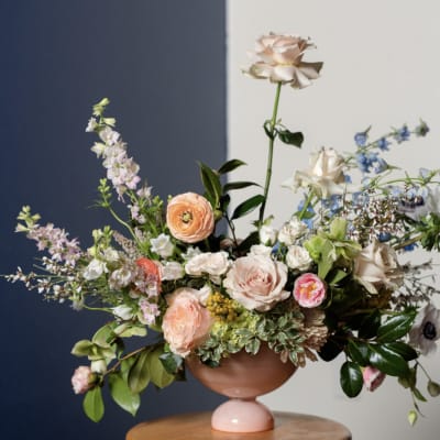 Pastel floral arrangement in a pink pedestal vase
