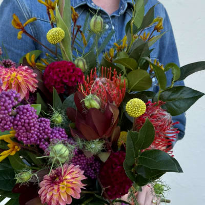 Gift card with a colorful bouquet held in front of a denim shirt