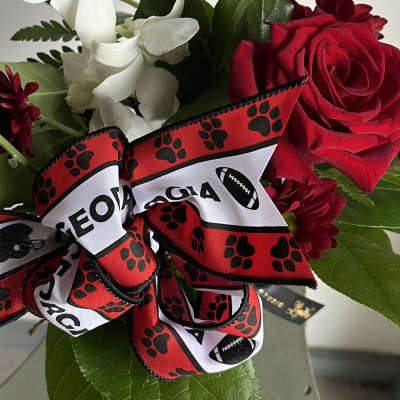 Red roses and white orchids with a football-themed ribbon