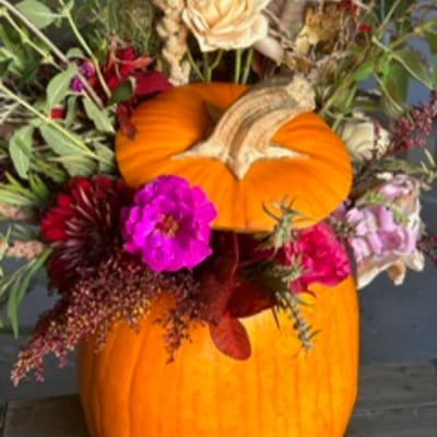 Floral arrangement with pumpkins and mixed fall flowers