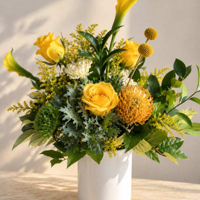 Yellow roses and mixed flowers in a white vase