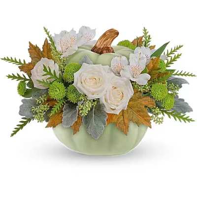 White roses and small white flowers in a pumpkin-shaped vase