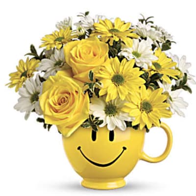 Yellow roses and daisies in a smiley-face mug