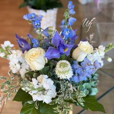 Blue and white floral arrangement in a clear glass vase