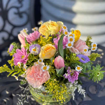 Mixed bouquet of pastel flowers in a clear glass vase