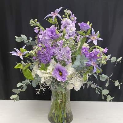 Purple and white bouquet in a clear glass vase