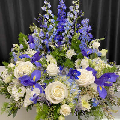 Blue and white floral arrangement with roses and iris flowers