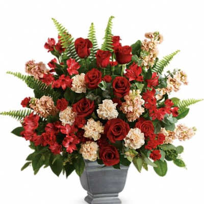Large red and cream flower arrangement in a gray urn-style vase