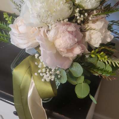 Blush and white bouquet in a glass vase with long ribbon tails