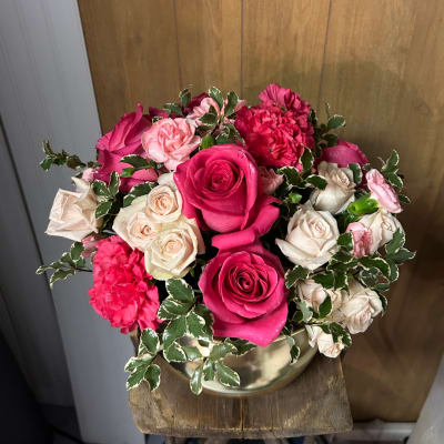 Pink and cream roses with carnations in a gold vase