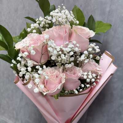 Pink roses with white baby's breath in pink wrapping