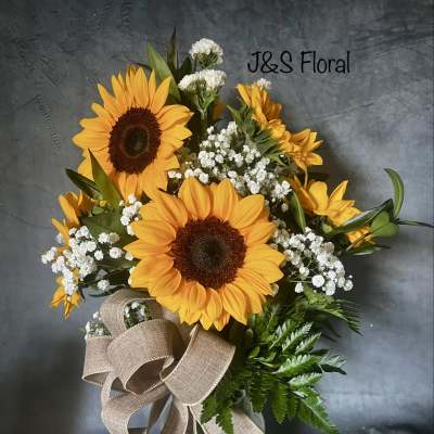 Sunflower bouquet in a glass vase with baby's breath and a burlap ribbon