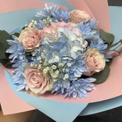 Bouquet of pale pink roses and blue flowers wrapped in pink and blue paper