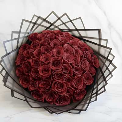 Bouquet of deep red roses wrapped in geometric black paper