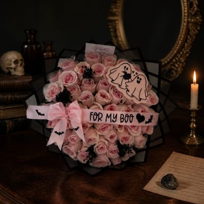 Pink rose bouquet with a ribbon and Halloween-themed decorations