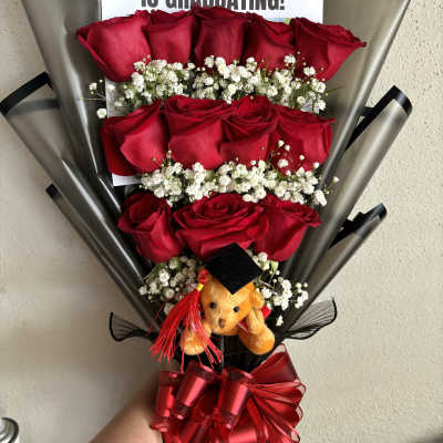 Bouquet of red roses with baby’s breath, graduation sign, and teddy bear