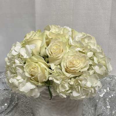 Cream roses and white hydrangeas in a white vase