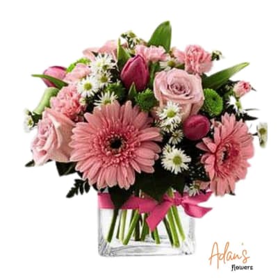 Pink mixed bouquet in a clear glass vase with a ribbon