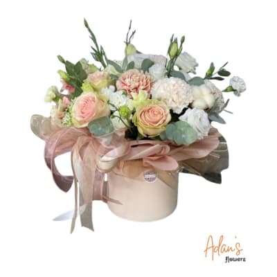 Pastel bouquet in a round hatbox with pink roses and white blooms