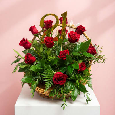 Basket of red roses with a gold "21" topper