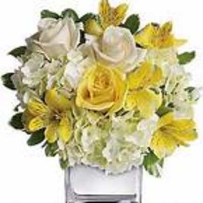 Yellow and white flower arrangement in a clear glass vase