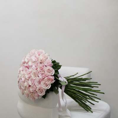 Bouquet of pale pink roses wrapped in white paper