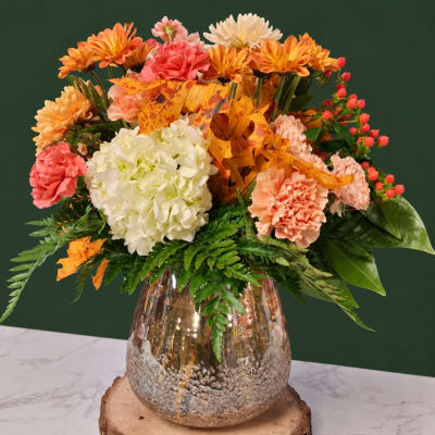 Autumn bouquet of mums, carnations, and hydrangea in a metallic vase