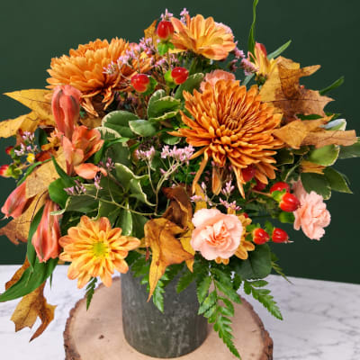 Autumn bouquet with orange chrysanthemums and pink carnations in a metal vase