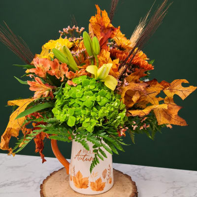Autumn bouquet in a white mug with orange handle and leaf print