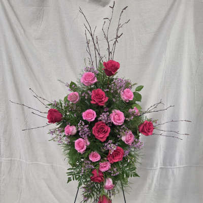 Tall standing spray of hot pink and light pink roses on a metal easel