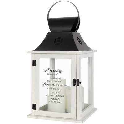 White memorial lantern with black metal top and white pillar candles inside