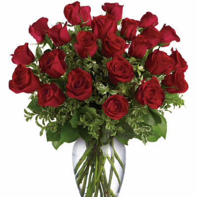 Tall arrangement of red roses in a clear glass vase of water