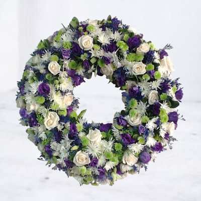 Circular wreath of white, purple, and green flowers